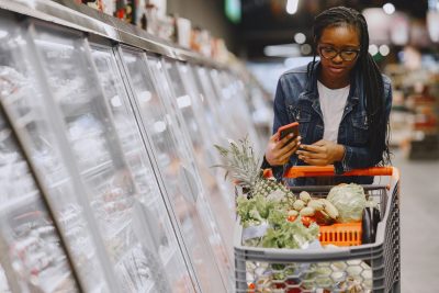 Shopper using a smartphone while grocery shopping